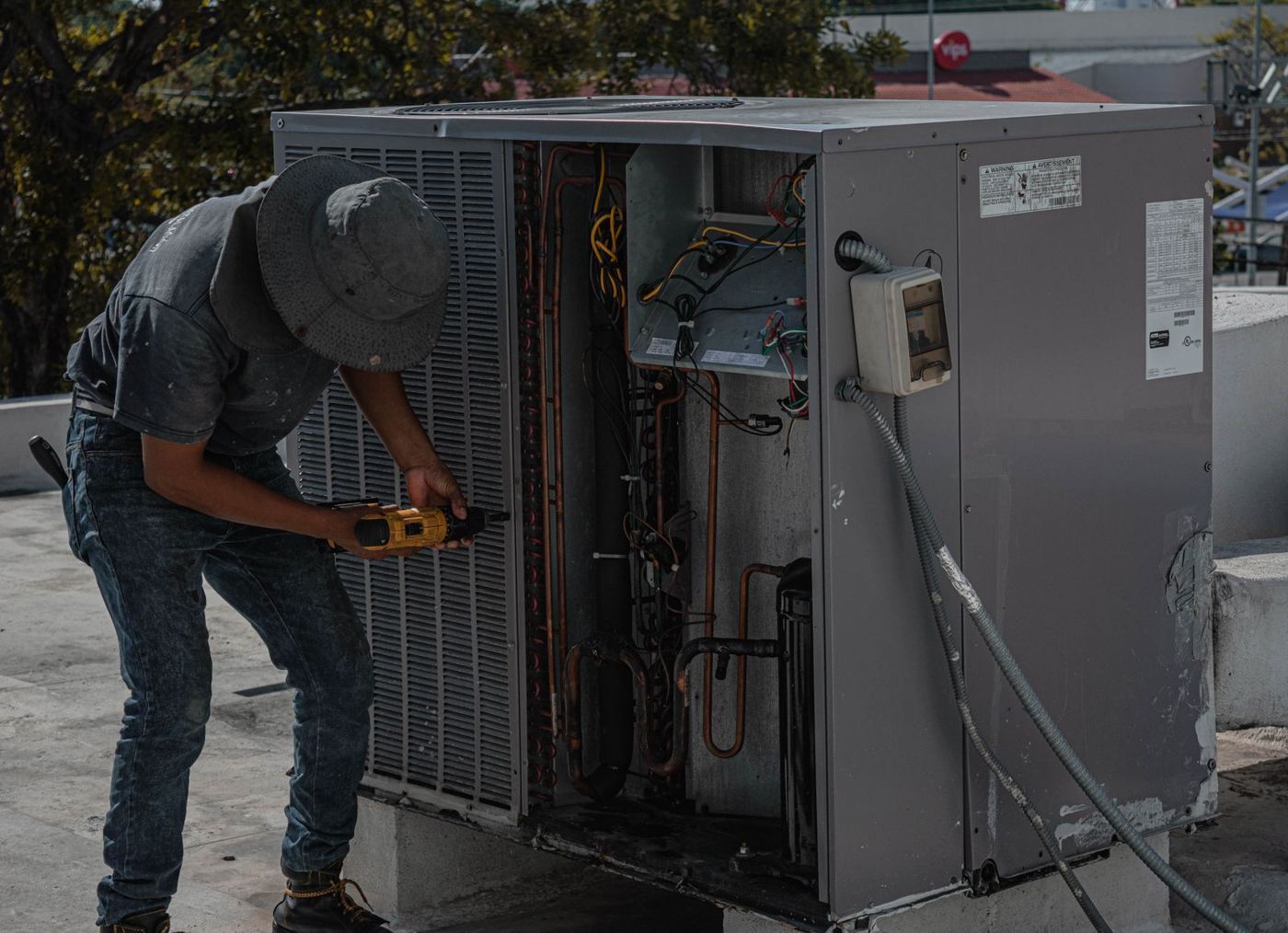 Technician working on a rooftop refrigeration unit